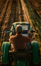 A tech savvy farmer seated on a tractor, using a laptop to assess drone collected data, such as aerial images of fields, while