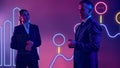 Tech-savvy professionals delivers dynamic presentation against neon lit screen with data analysis and insights.