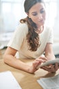 Tech savvy and successful. a young businesswoman using a digital tablet.