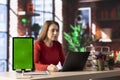 Tech savvy user working on pc to test a software next to green screen Royalty Free Stock Photo