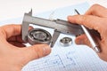 Technical drawing and callipers with bearing in hand Royalty Free Stock Photo