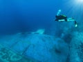 Technical Scuba diver is exploring a sunken wreck