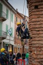 A technician from Acrobatica ascends the church wall using rope access techniques during setup for an aerial art performance, in Royalty Free Stock Photo