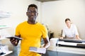 Technician african american working of printing house with stack of notebooks in her hands