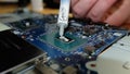 Technician applying thermal paste to an Intel Core i7 8750H CPU or processor Royalty Free Stock Photo