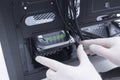 Technician assembling computer hardware parts. Hard drive being installed in a new computer Royalty Free Stock Photo