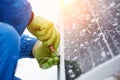 Technician in blue suit installing blue solar panels with screw. Royalty Free Stock Photo