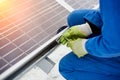 Technician in blue suit installing blue solar panels with Royalty Free Stock Photo