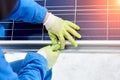 Technician in blue suit installing blue solar panels with Royalty Free Stock Photo