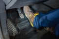 Technician with boots testing the brake pedal of a car during a vehicle inspection Royalty Free Stock Photo