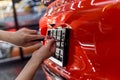 Technician changing car plate number in service center.