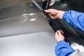 Technician is changing windscreen wipers on a car station.