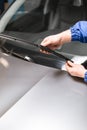 Technician is changing windscreen wipers on a car station.