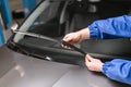 Technician is changing windscreen wipers on a car station. Royalty Free Stock Photo