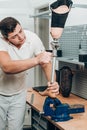 Technician checking artificial limb while at desk in workshop, adjusting it and checking for quality Royalty Free Stock Photo