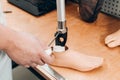 Technician checking artificial limb while at desk in workshop, adjusting it and checking for quality Royalty Free Stock Photo