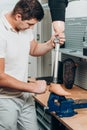 Technician checking artificial limb while at desk in workshop, adjusting it and checking for quality Royalty Free Stock Photo