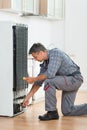 Technician Checking Fridge With Multimeter At Home Royalty Free Stock Photo