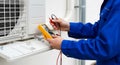 Technician checking the voltage of air conditioner with multimeter tool Royalty Free Stock Photo