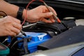 technician checks the battery using a voltmeter capacity tester,auto mechanic uses a multimeter voltmeter to check the voltage Royalty Free Stock Photo
