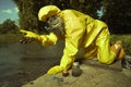 Technician in chemical protective suit controlling water contamination Royalty Free Stock Photo