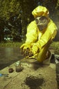 Technician in chemical protective suit measuring water contamination Royalty Free Stock Photo