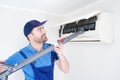 Technician cleaning air conditioner filter on the wall at home for hvac service Royalty Free Stock Photo