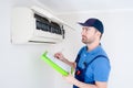 Technician with clipboard checking air conditioner for installation estimate Royalty Free Stock Photo