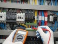 Technician conducting electrical panel inspection with multimeter Royalty Free Stock Photo