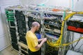 A technician connects Internet backbones with a central router. Worker lays telecommunication cables in the server room. A man