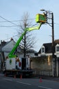 Bucket truck in a street of a town in Brittany with an electrician working on public lighting Royalty Free Stock Photo