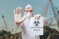 Technician in coverall warns in landfill about hazardous waste Royalty Free Stock Photo