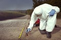 Technician Criminologist preparing tire print left in dust of field way for documentation Royalty Free Stock Photo