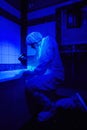 Technician criminologist working under UV light