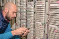 Technician cuts a telephone wire near a patch cross panel. Man works with pliers in the server room of an analog telephone Royalty Free Stock Photo