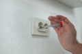 The technician determines the voltage in the socket. Royalty Free Stock Photo