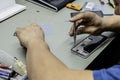 A technician disassembling the inside of a telephone on his workshop table