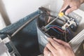 A technician dismantles the inside of a outdoor compressor unit of a Split type air conditioner. Repair or maintenance work Royalty Free Stock Photo