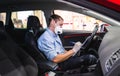 Technician doing a security inspection inside a vehicle protected with a mask and gloves to prevent the spread of virus