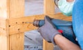 Technician drilling wooden box with drilling machine. Heavy machinery container for transport. Technician carpenter wear safety Royalty Free Stock Photo