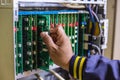 Technician or engineer changes the motherboard, PBX, telephone with flashing lights indicating the digital system Royalty Free Stock Photo