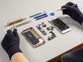 Technician repairing broken smartphone on desk Royalty Free Stock Photo