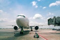 Technician or engineer safety check of modern passenger or cargo airplane parking at terminal gate of international airport on a