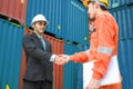 Technician and engineer shake hand in cargo container area with concept collaborative working