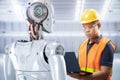 Technician or engineer work with robot in factory Royalty Free Stock Photo