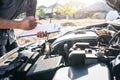 Technician engineer working of car mechanic in doing checklist for repairs engine writing to the clipboard repairing vehicle, Royalty Free Stock Photo