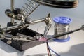 Technician engineer in the workshop. The repairer solders the electronics board on the table Royalty Free Stock Photo
