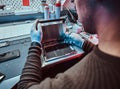 The technician repairs a broken tablet computer in a repair shop