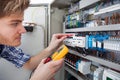 Technician examining fusebox with insulation resistance tester