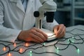 Technician examining led circuit board under microscope for precision soldering technique in laboratory. concept of electronics Royalty Free Stock Photo